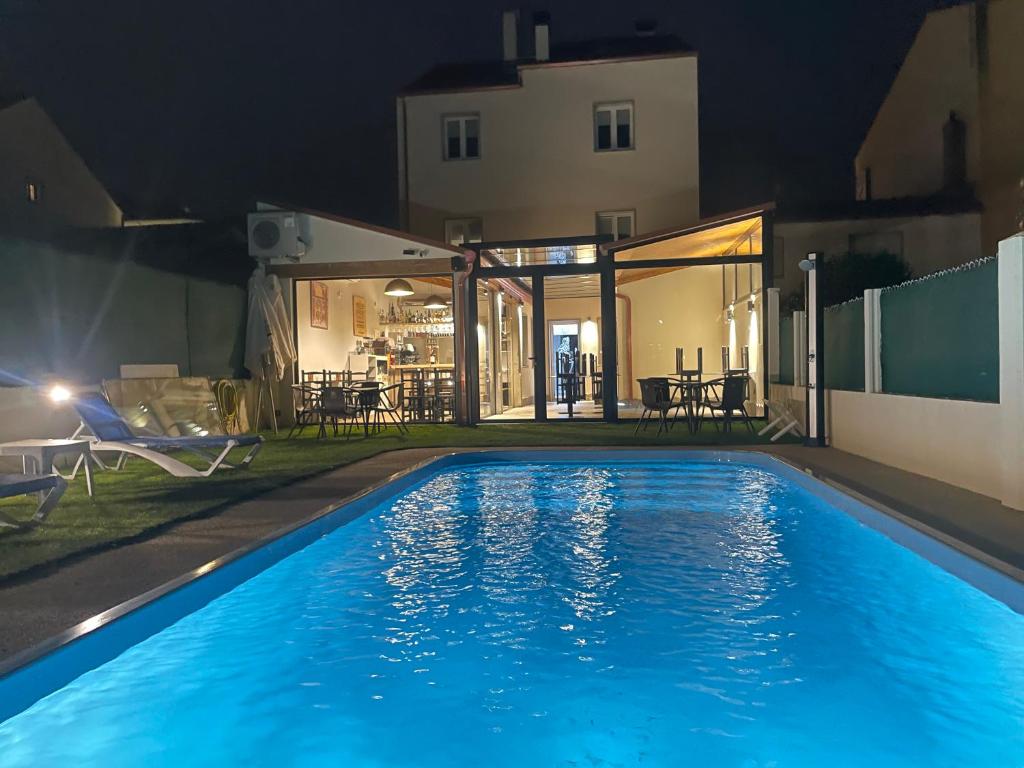 a swimming pool at night with a house at Pension San Anton in Melide