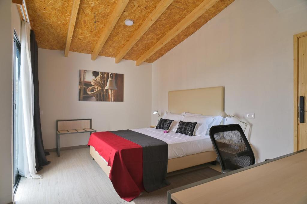 1 dormitorio con 1 cama con manta roja y negra en Encosta Azul Guesthouse en Cidade Velha