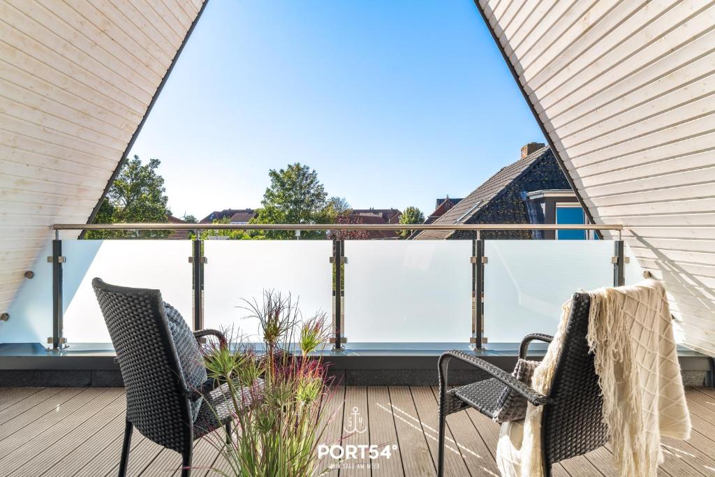 a view from the balcony of a house with two chairs at Ferienwohnung Insellodge Fehmarn in Fehmarn