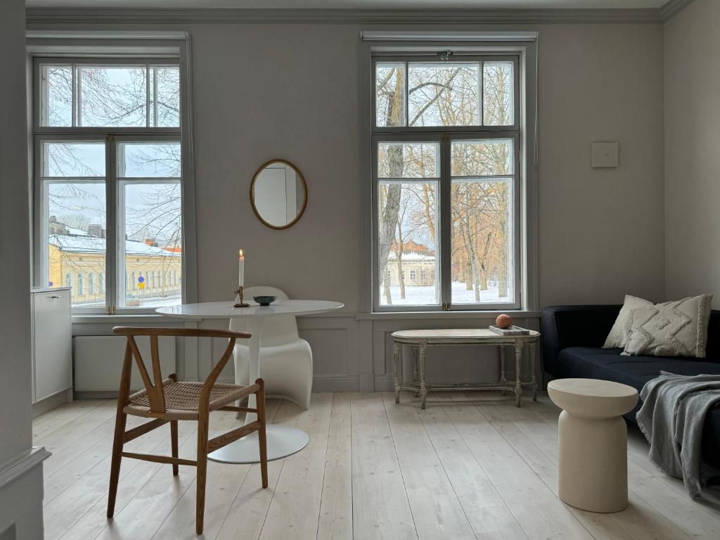 uma sala de estar com um sofá e uma mesa em Uniikki ja tunnelmallinen empireasunto Hämeenlinnan ydinkeskustassa em Hämeenlinna