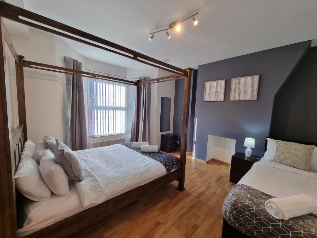 a bedroom with a bed and a large window at Charming 3 bed house near Liverpool stadium 10 mins drive to city centre in Liverpool