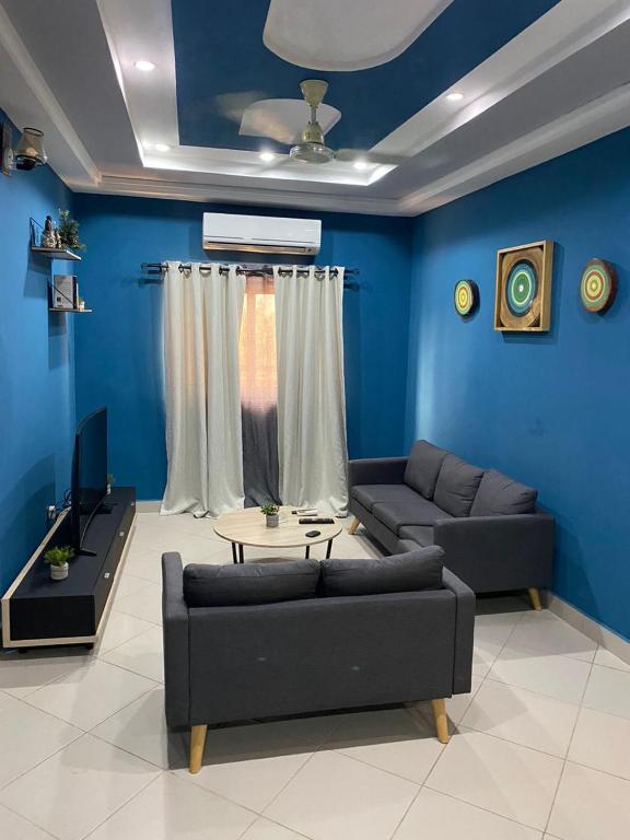 Abomey-Calavi的住宿－AGENCE IMMOBILIÈRE GDS BENIN，客厅设有蓝色的墙壁、一张沙发和一张桌子