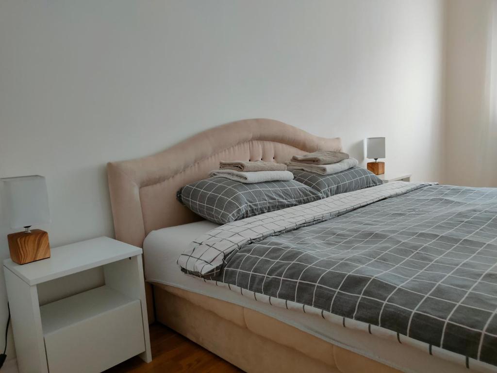 a bedroom with a bed with a gray comforter at Apartman Aleksandar in Zvornik