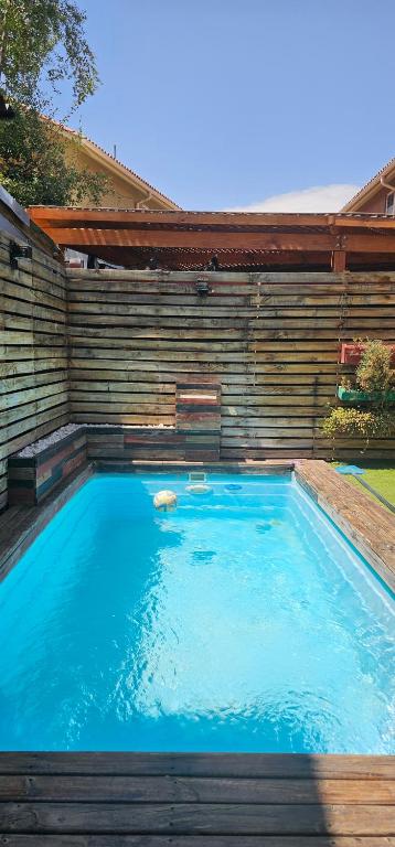 una piscina in un cortile con una parete in legno di Casa con piscina en San Bernardo a Santiago