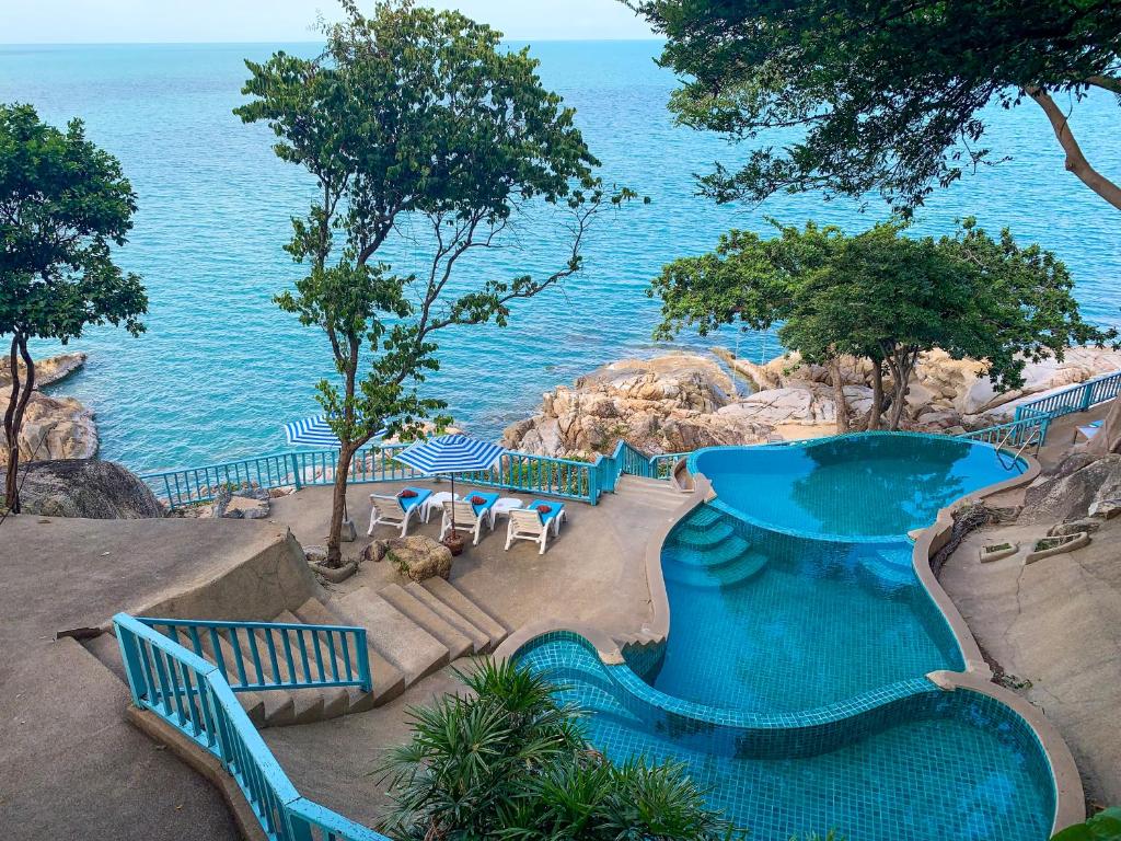 un complexe avec une piscine et l'océan dans l'établissement Baan Hin Sai Resort & Spa, à Chaweng Noi Beach