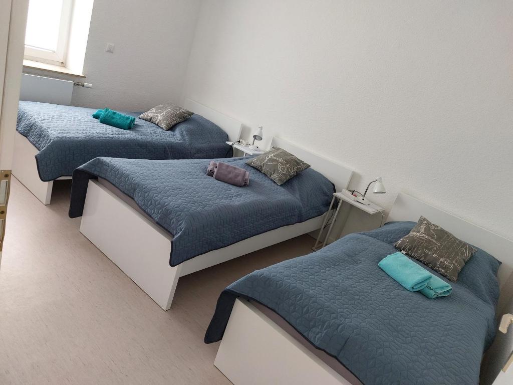 2 Betten in einem Zimmer mit blauer Bettwäsche und Kissen in der Unterkunft JoPit Haus in Baesweiler