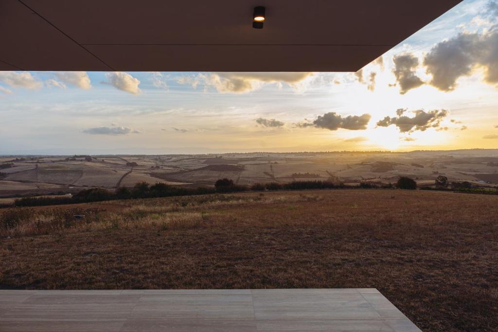 una vista su un campo con il tramonto da una casa di The Cloud at Sen Vineyard a White Hills