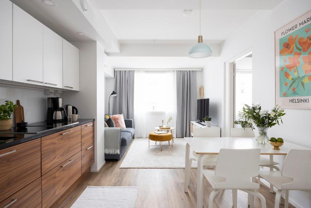 a kitchen and living room with a table and chairs at Stylish Flat in Trendy Kallio in Helsinki