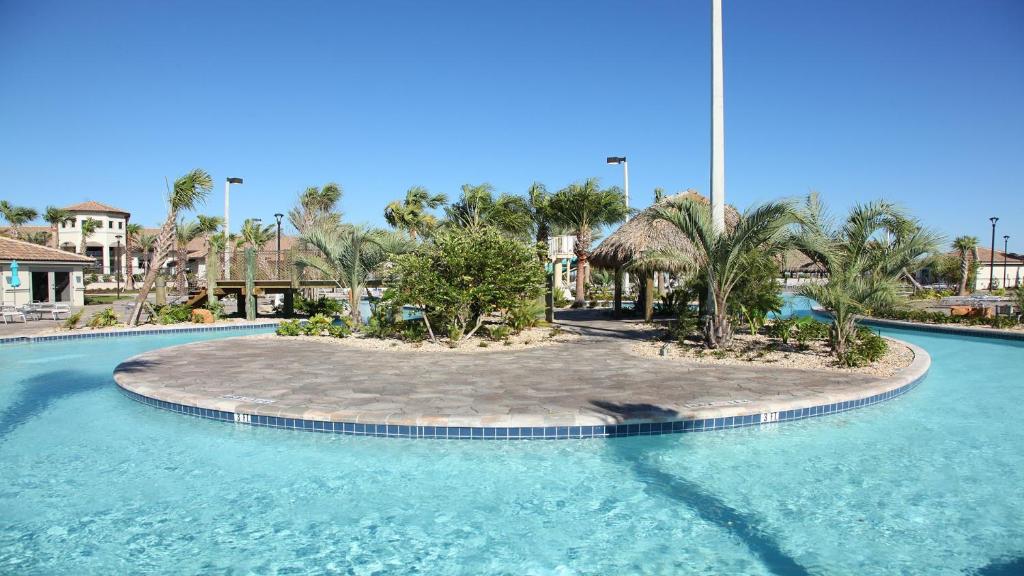 uma grande piscina com palmeiras e um resort em Champions Gate 6br Cozy Home With Pool Spa 8927 em Orlando