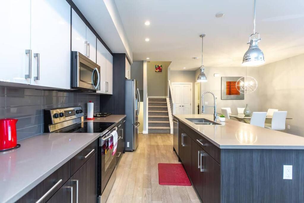 uma cozinha com um lavatório e uma bancada em Cozy Gems of Kensington em Calgary