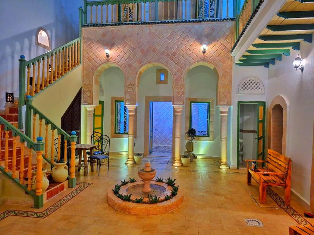 une grande chambre avec un escalier et une fontaine dans l'établissement Dar Baaziz 3, à Sousse