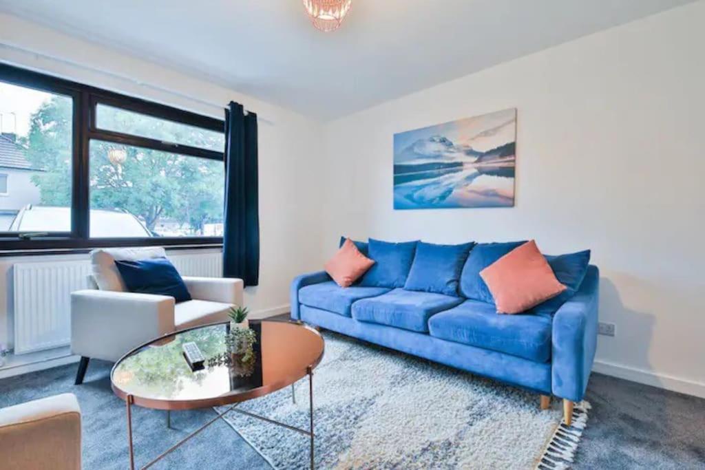 sala de estar con sofá azul y mesa en Eco Home for Large Groups w/ FREE Parking & Wi-Fi en Bristol