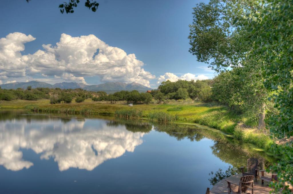 een rivier met een reflectie van wolken in het water bij Blue Lake Ranch in Hesperus