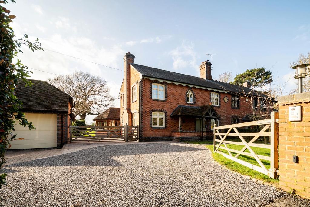 a brick house with a gate and a garage at Oak Cottage, HS2, NEC, BHX, M42, Family Gatherings, Contractors, Relocators in Birmingham