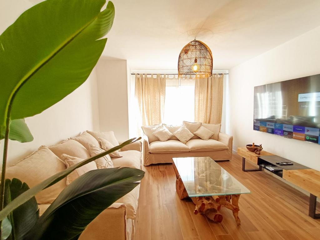 een woonkamer met een bank en een tafel bij Chakra House Fuerteventura in Corralejo