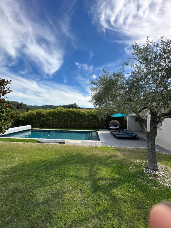 uma piscina num quintal com uma árvore em Villa vue imprenable sur château em Ansouis