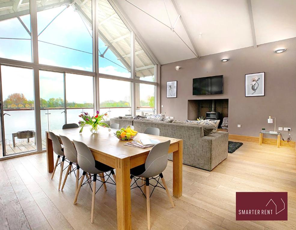 a dining room and living room with a table and chairs at Clearwater - Lower Mill in Somerford Keynes