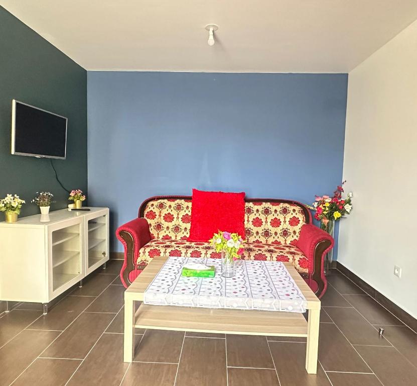 uma sala de estar com um sofá vermelho e uma mesa em Sweat Home em Sevran