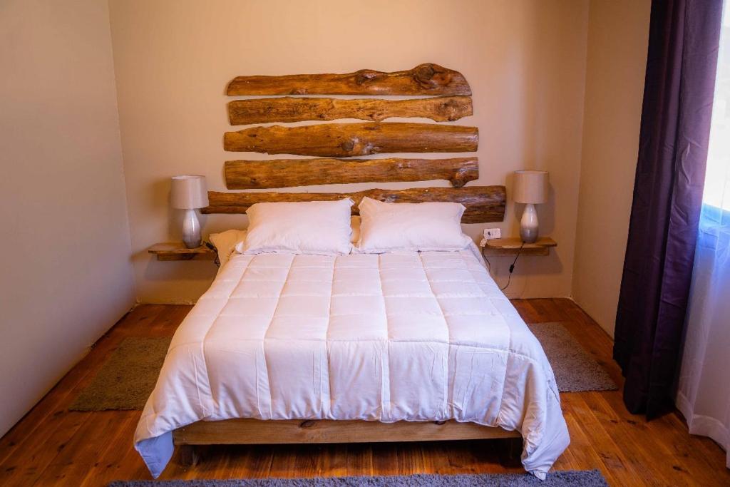 Schlafzimmer mit einem großen Bett mit einem Kopfteil aus Holz in der Unterkunft Casona Pretton in Valparaíso