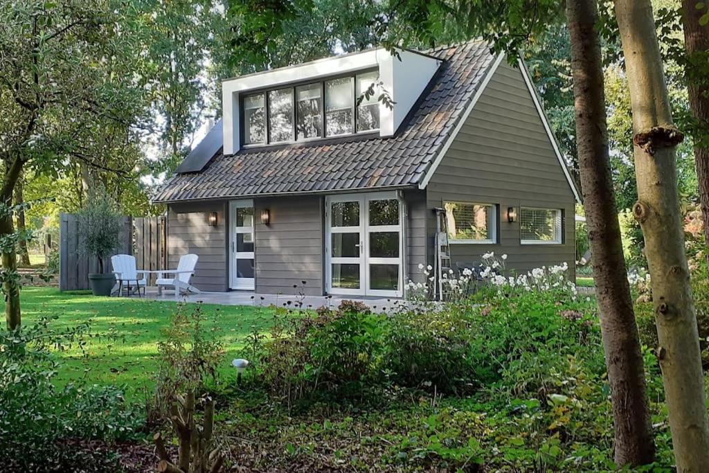 a small house with a balcony on top of it at Vakantiehuis De koolmees, in een bosrijke natuur. in Kaatsheuvel