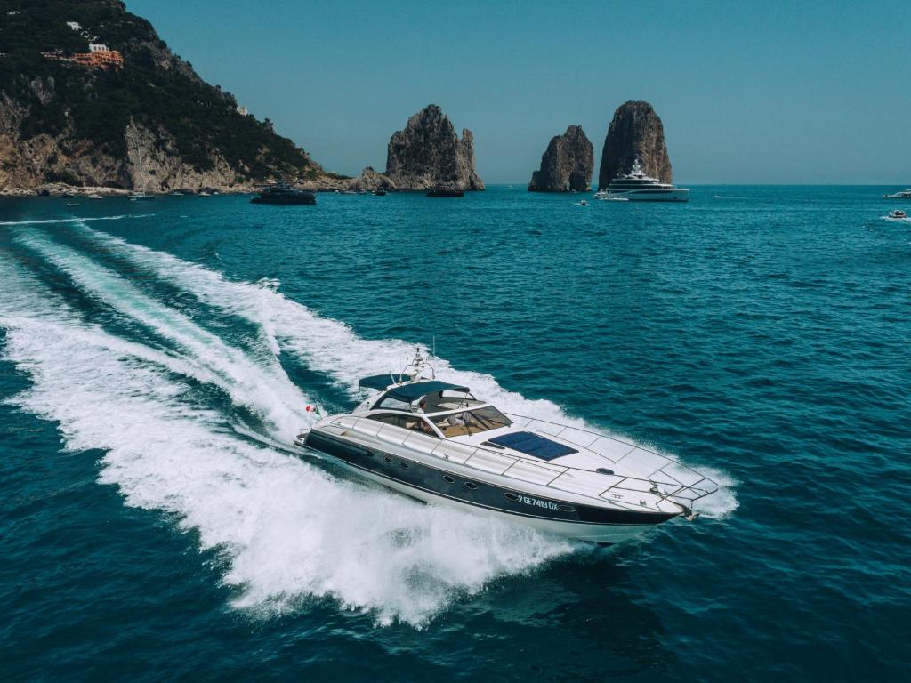 a boat in the water with rocks in the background at Live the Unforgettable on a Princess V55 in Sorrento