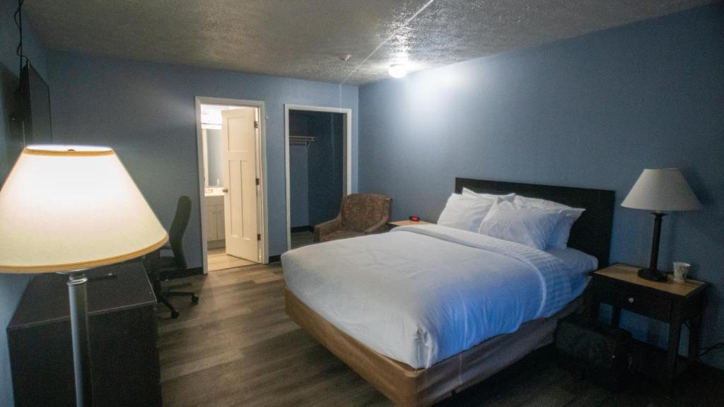 una camera con un letto con una parete blu di Ashley Motel a Plainfield