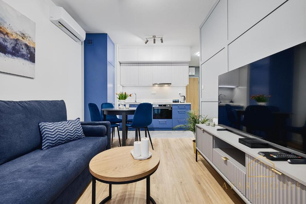 Una sala de estar con un sofá azul y una mesa. en Kilińskiego Residence, en Łódź