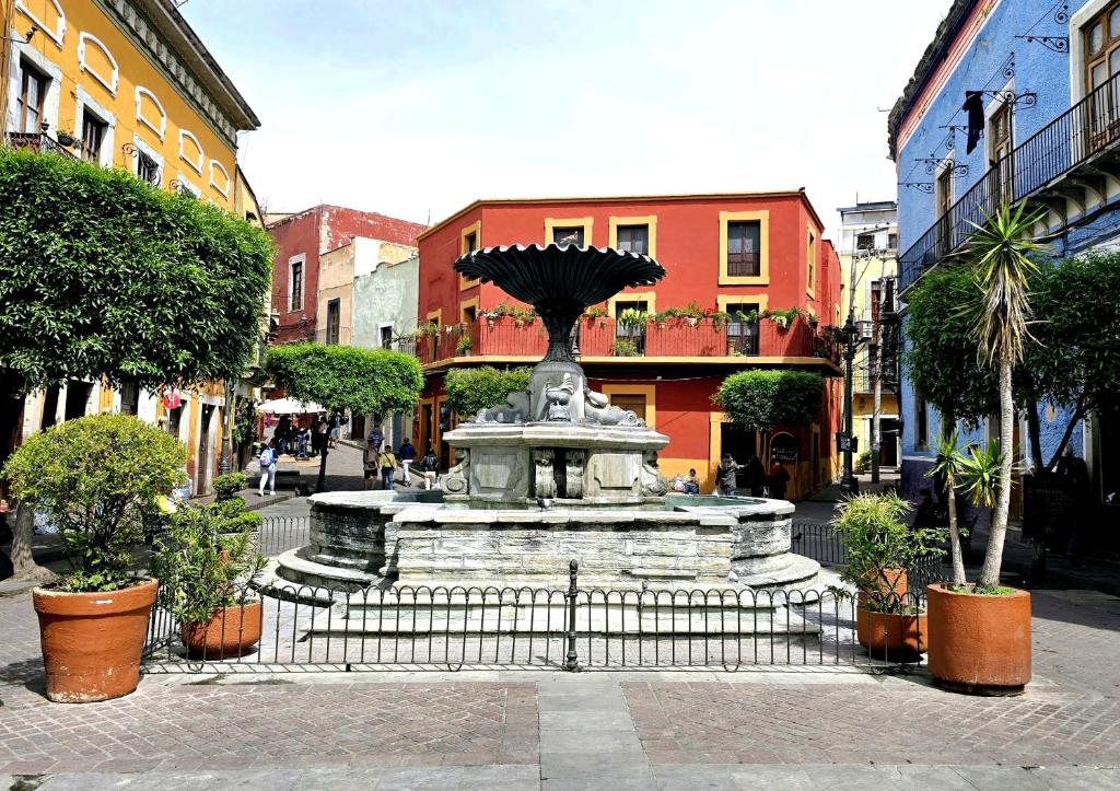 a fountain in the middle of a street at Hotel Plaza Baratillo in Guanajuato