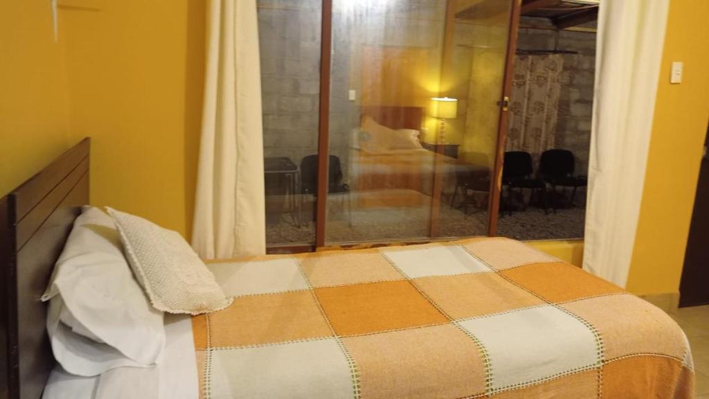 a bedroom with a bed with a window and a room at Taffy's House in San Pedro de Atacama
