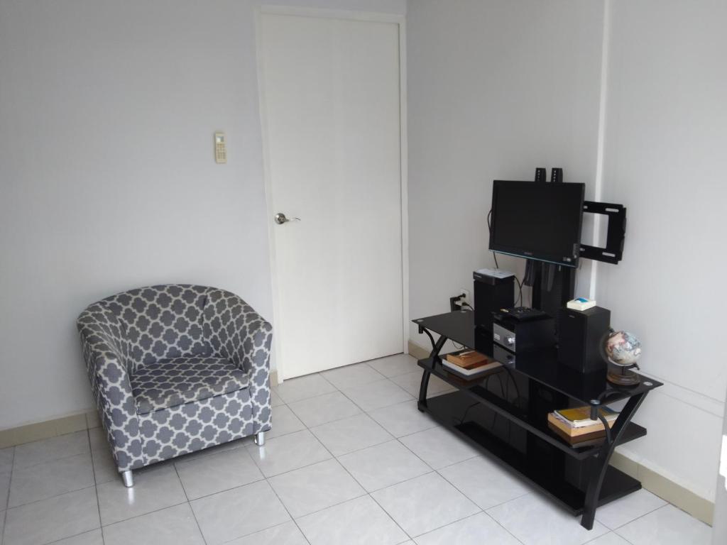 a living room with a chair and a tv at Pequeño y acojedor departamento muy bien ubicado in Veracruz