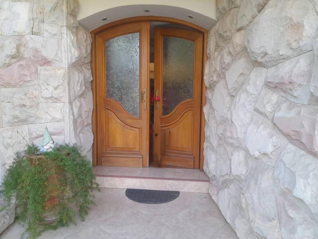 drewniane drzwi wejściowe do kamiennego budynku w obiekcie Elegante piso en barrio privado w mieście Godoy Cruz
