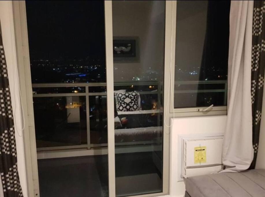 a room with a window with a view of a city at Penthouse Apartment in Paranaque in Manila