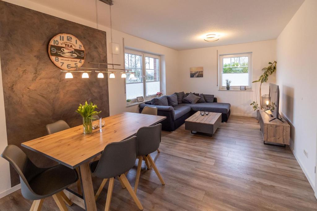a living room with a table and a couch at Ferienhaus Meerträume in Pewsum