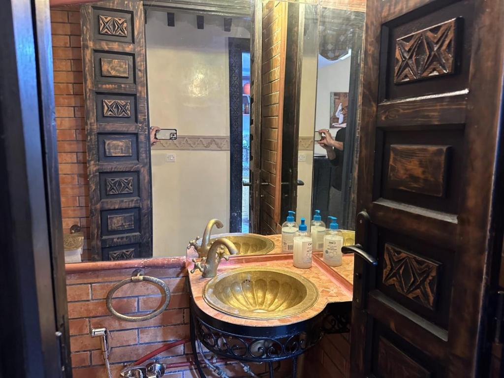 baño con lavabo de oro y espejo en RIAD Anis en Marrakech