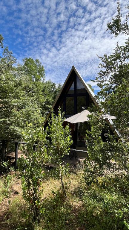 a small house with a roof in the woods at Refugio de bosque altos de ñancul in Panguipulli