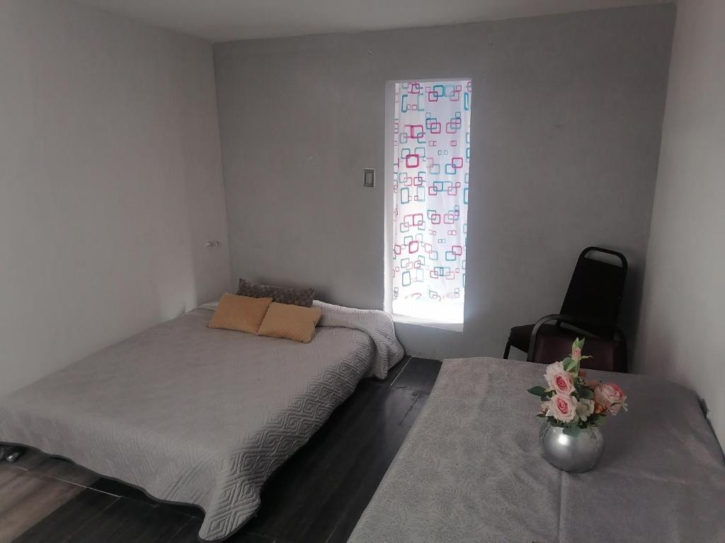 een slaapkamer met 2 bedden en een raam bij Habitación cómoda y tranquila in Mexico-Stad