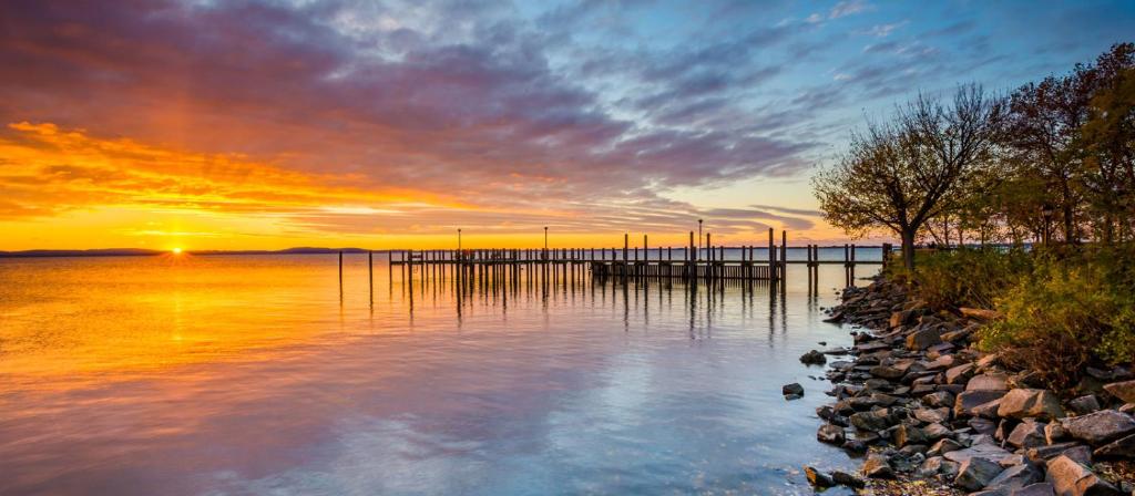 a sunset over a body of water with a dock at Weiss Lake Lodge in Centre