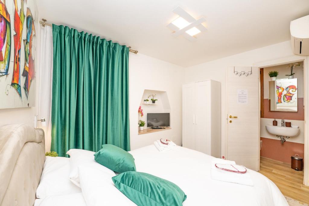 Habitación con cama y cortina verde en Isa Sweet Home en Venecia