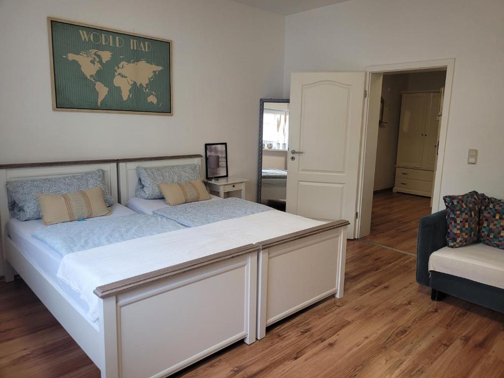 ein Schlafzimmer mit einem großen Bett und einem Stuhl in der Unterkunft Gästehaus Kampik in Witten
