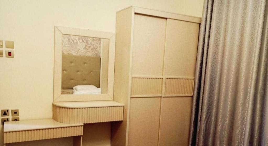 a dressing room with a mirror and a curtain at Al Asar almasi Suite Apartments in Medina