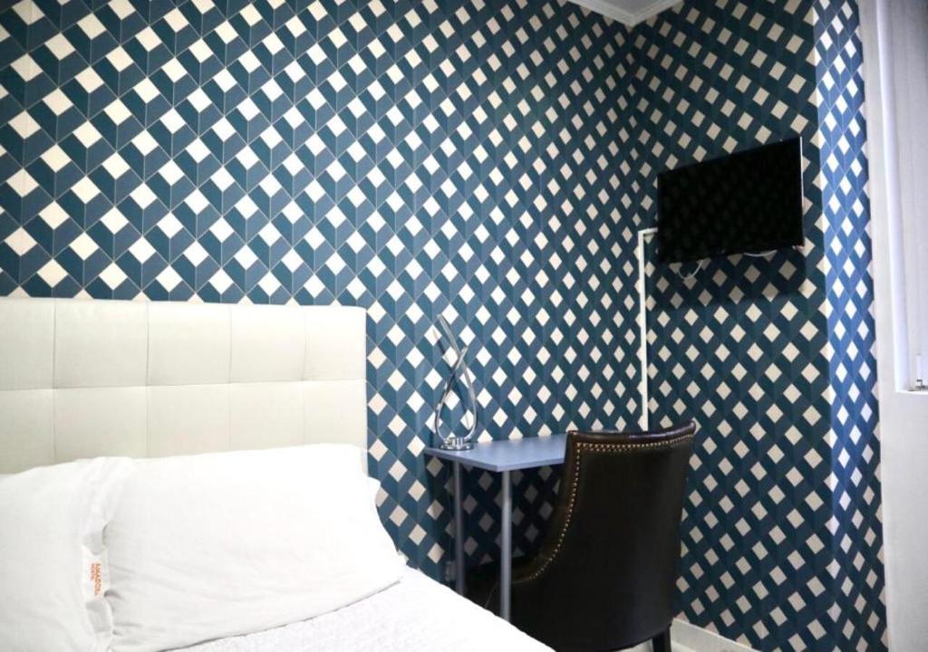 アマドーラにあるAmadora Cozy Houseの青と白の模様の壁のベッドルーム