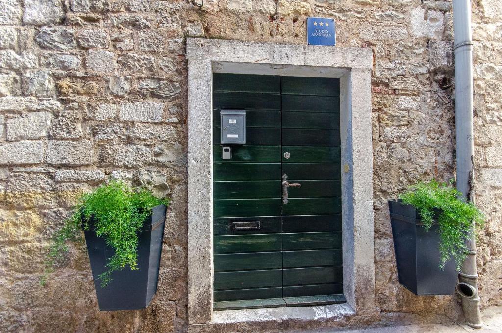 a green door with two potted plants next to it at Apartments Urban in Split