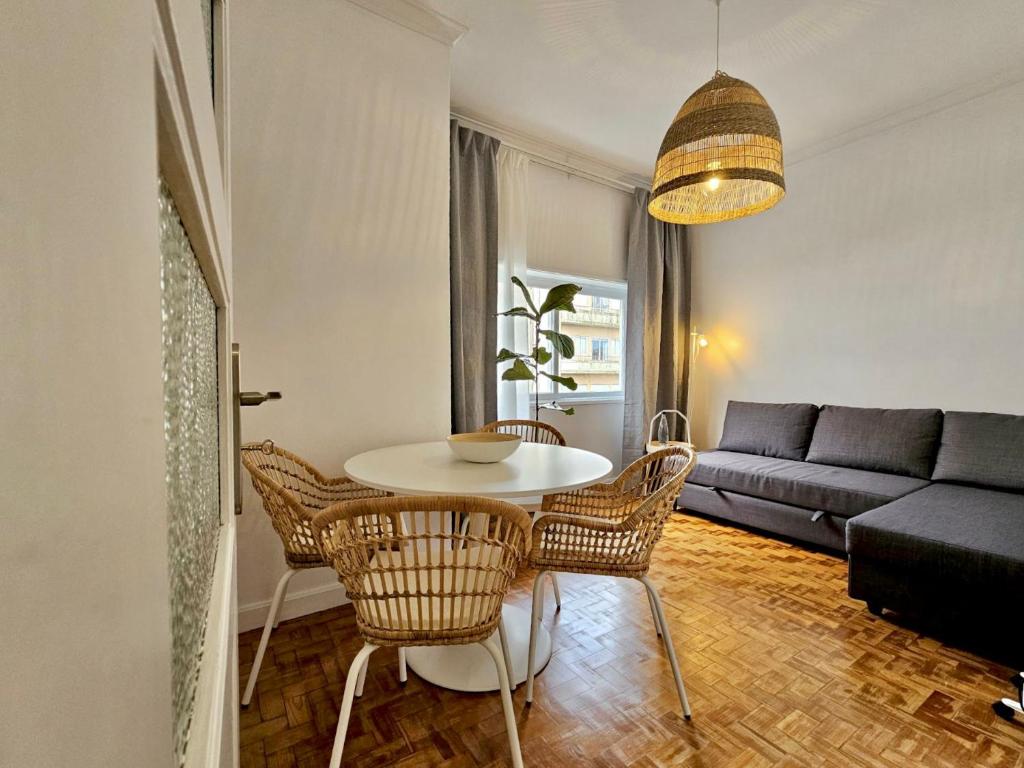 a living room with a table and chairs and a couch at LM art apartments in Porto