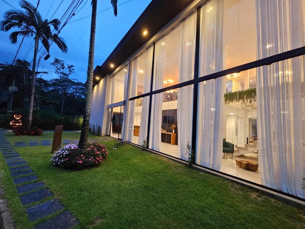 a house with large windows and a green yard at Pousada Menino de Ouro in Penedo