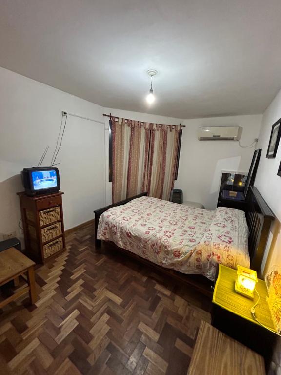 1 dormitorio con 1 cama y TV. en Departamento en Alta Córdoba con patio en Córdoba