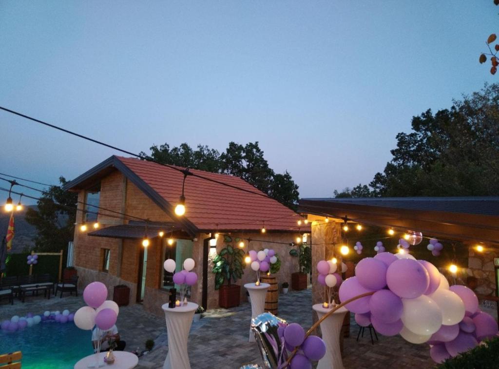 a party with purple and white balloons in front of a house at Vila Ohana in Skopje