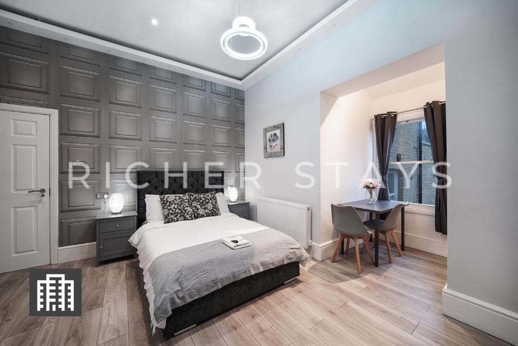 1 dormitorio con cama y escritorio en Hackney Suites - En-suite rooms & amenities, en Londres