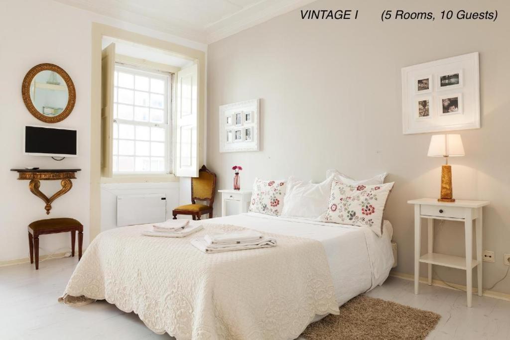 Dormitorio blanco con cama blanca y espejo en Alfama Vintage 1 Ten guests - Alfama Vintage 2 Five guests - Alfama Vintage 3 Three Guests, en Lisboa