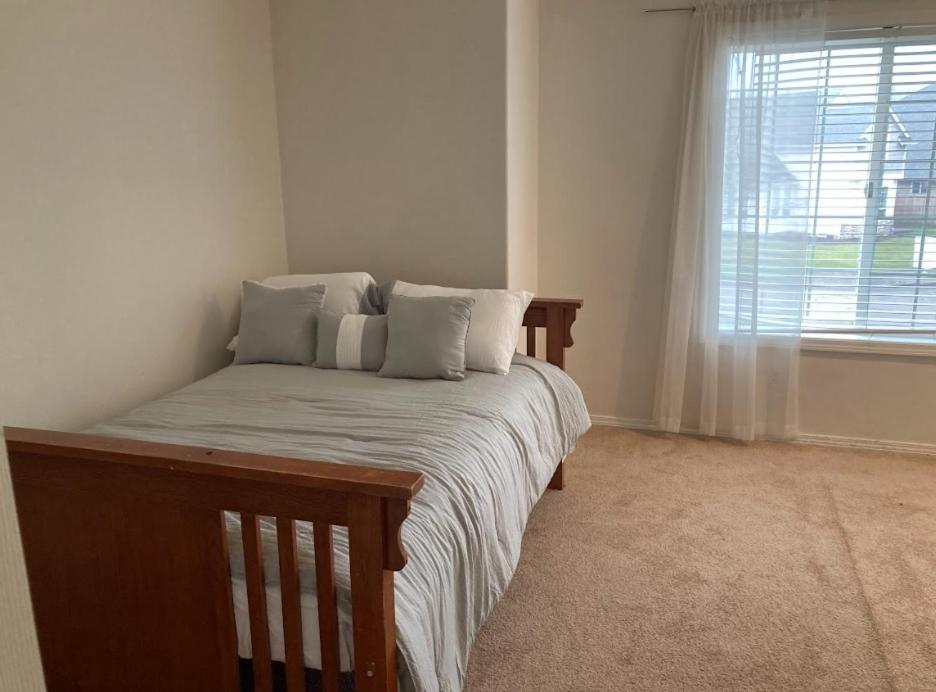um quarto com uma cama com almofadas e uma janela em Home sweet home em Hillsboro