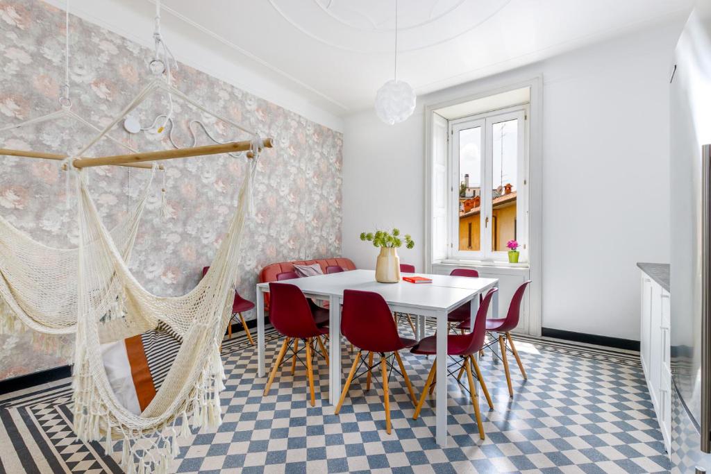 een eetkamer met een witte tafel en rode stoelen bij FEEL - Palazzo Centrale in Bergamo